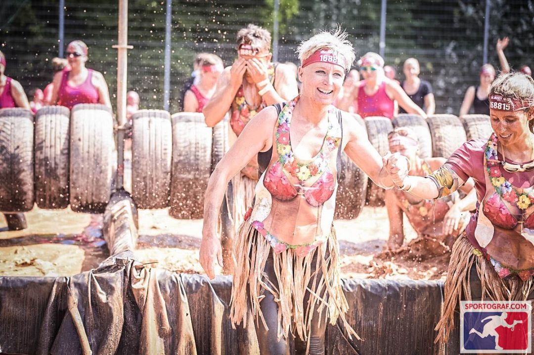 Lizzi und Claudi beim Schlammlauf. Lizzi nimmt ihre helfende Hand. 