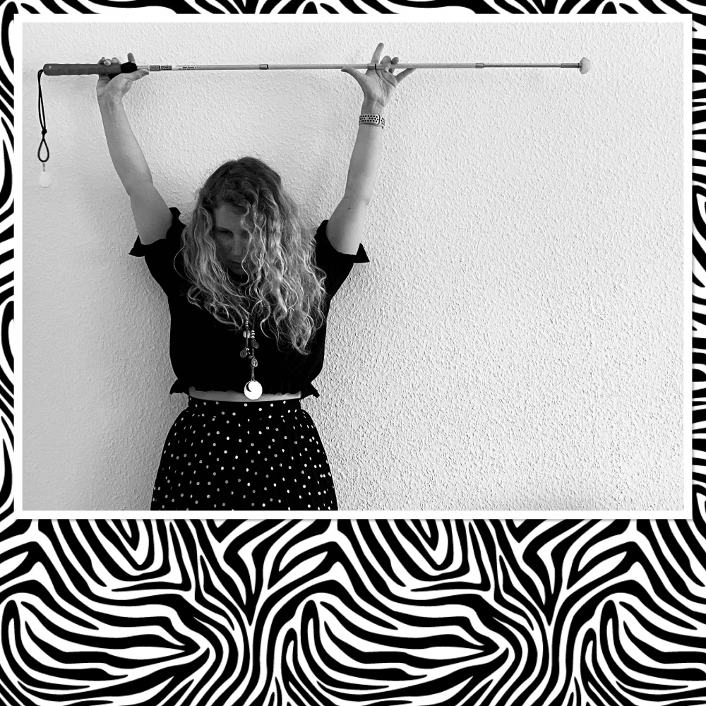 Lizzi hält den Langstock über sich.