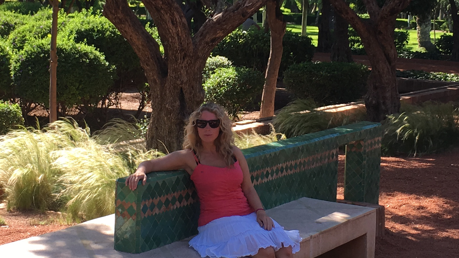 Lizzi auf einer beschatteten Bank in einer Grünanlage in Marrakesch.